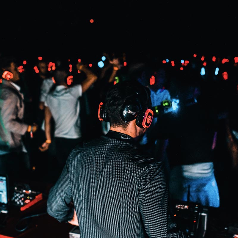 Une personne passe de la musique pendant que le public écoute au casque